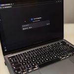 AI Tools Every Mumpreneur Should Know Close-up of a laptop showing an AI chat interface in a dimly lit room.